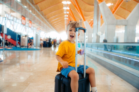 Young boy feeling excited for travel on luggage