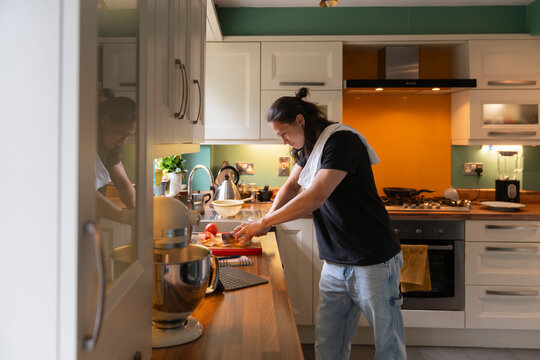 Chopping Fresh Vegetables in a Cozy Kitchen for a Homemade Meal