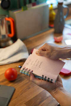 Anonymous Man Makes Grocery List in Kitchen While Checking Tablet
