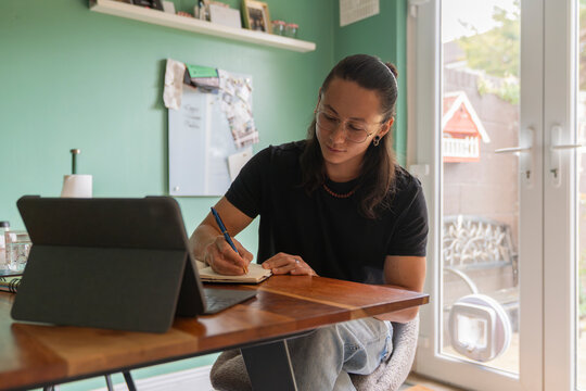 Man Studying and taking notes in a cozy Home indoors