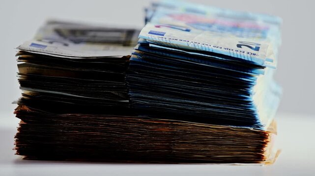 Slow motion rotating euro cash stack shows savings, pensions, and pressure