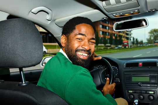 Happy man drives his car through the city
