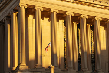 Classical building columns with American flag at golden hour