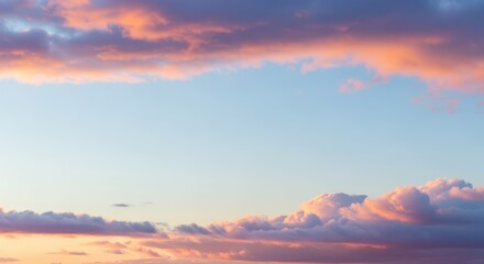 Delicate pastel colored clouds frame clear blue sky space during twilight