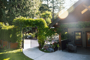 Cozy home entrance with ivy arch and sunlit patio outdoor space