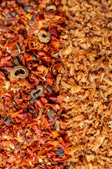 Mix of dried vegetables. Spices red and brown close-up, top view. Dried onion with paprika, tomatoes and olives. Universal seasoning from chopped vegetables