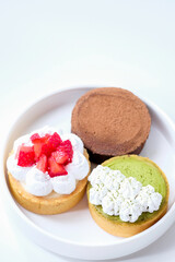 Various kinds of mini cheese tarts on a white plate