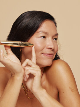 Woman Showcasing Skincare Tool for Glowing Complexion