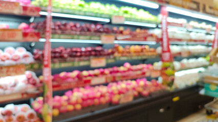 Blurred image of fruit displays in a supermarket, showcasing colorful produce arranged on shelves