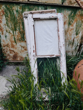 Old window frame in overgrown grass