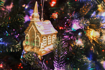 Ice house toy on a Christmas tree with colorful lights