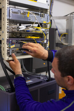Technician Repairing Network Equipment in a Server Room