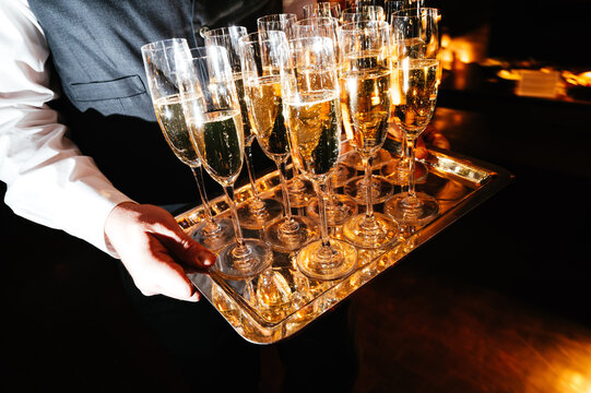 Waiter holding tray of champagne flutes
