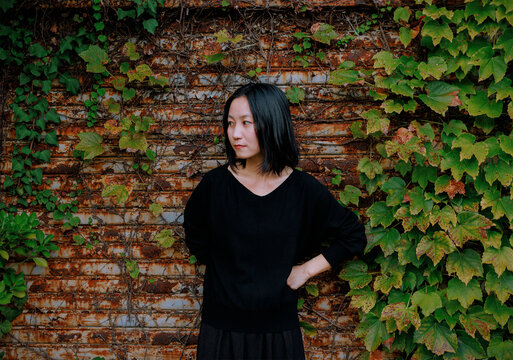 A Resigned Gaze: Woman in Front of an Industrial Ruin.