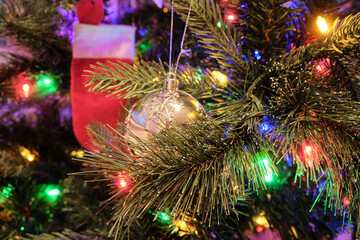 Glass ball toy on a Christmas tree with colorful lights