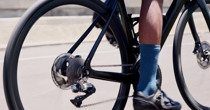 Athlete, feet and cycling with bicycle in road for fitness exercise, pace training or performance. Cyclist, person or bike ride outdoor for cardio workout, triathlon practice or competition challenge