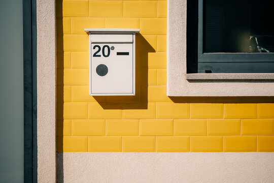 Modern Mailbox on a Bright Yellow Wall in an Urban Setting