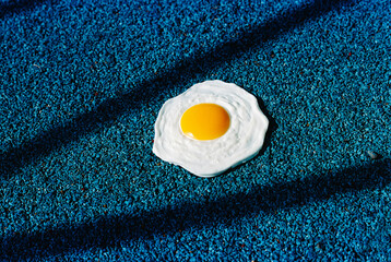 fake fried egg on a blue textured surface, 35mm film