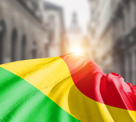 Mali flag fluttering on blur street with building. Mali national flag for independence day.