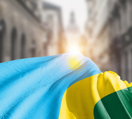 Rwanda flag fluttering on blur street with building. Rwanda national flag for independence day.