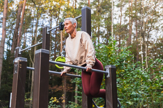 Woman Using Outdoor Gym Equipment in a Forest
