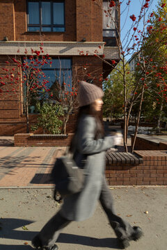 Woman rushing through city street during autumn commute