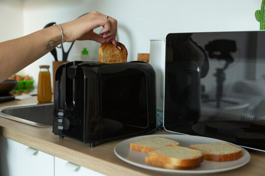 Woman's hand making toast for breakfast