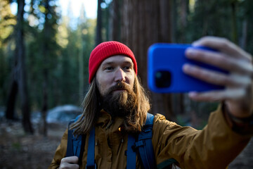 Man photographs in a redwood forest