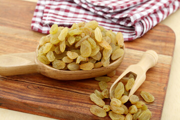 Close up of raisins spilled out of wooden scoops