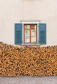 Rustic Window With Teal Shutters And Stacked Firewood On Beige S