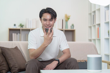 Technology and Lifestyle: Young man engaging with smartphone for video call at home