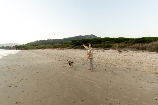 Man throwing frisbee as dog chases