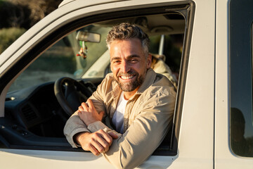 Man smiling from driver seat of camper van