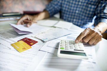 asian man alculate credit card expense. check balance in savings account before paying off the debt