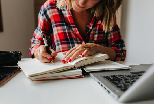 Hands of woman writing in open notebook