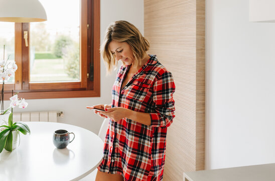 Woman using phone in kitchen