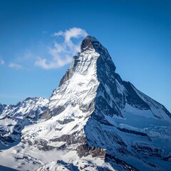 Snowy mountain peak against a clear, bright blue sky with wisps of cloud