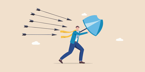 Businessman defends against incoming arrows with a shield