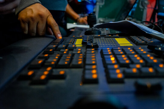 Lighting engineer hand operating control console at event - Powered by Adobe