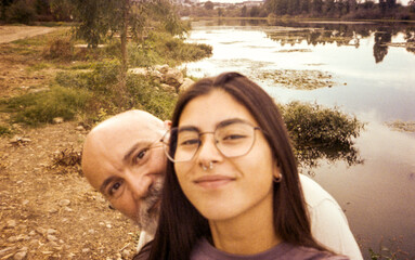 film selfie of bearded father and adult daughter by the river