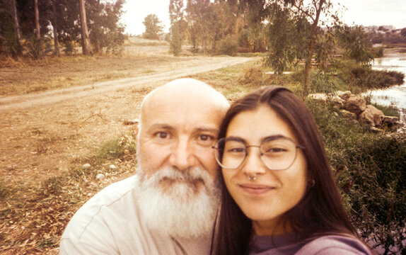 film selfie of bearded father and adult daughter by the river