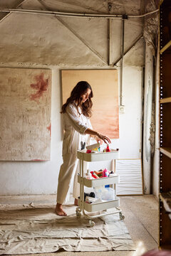 Artist prepares materials in bright studio space for creative wo