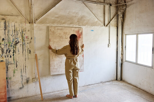 Artist working on a canvas in a sunlight-filled studio