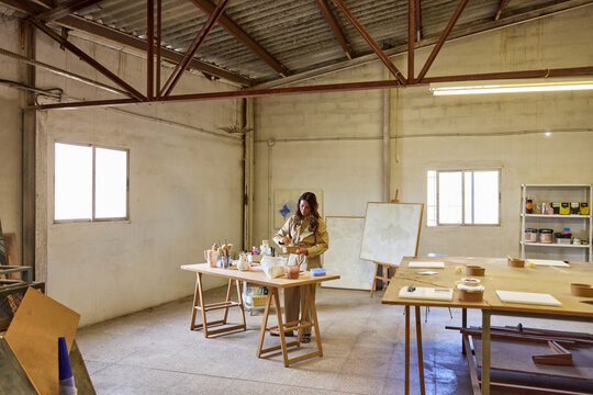 Artist prepares materials in a spacious studio during the day