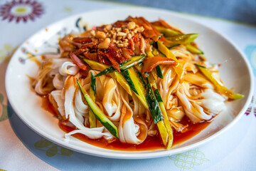 A plate of sweet and sour traditional Guangxi-style dry rice noodles with char siu