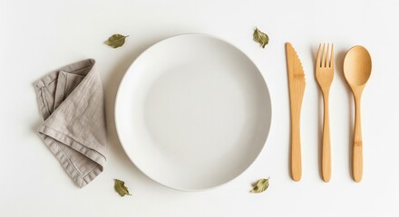 White empty plate and silverware setting on a wooden table