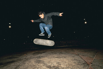 Skateboard Trick Over Rail at Night