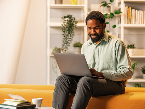 Man Working on Laptop at Home Office with Plants and Books
