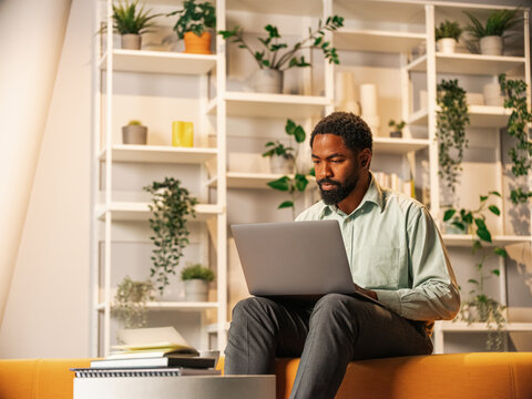 Professional Black Man Working On Laptop In A Cozy Modern Office 