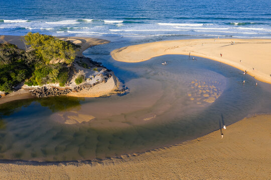 Beachgoers palying in a coastal stream